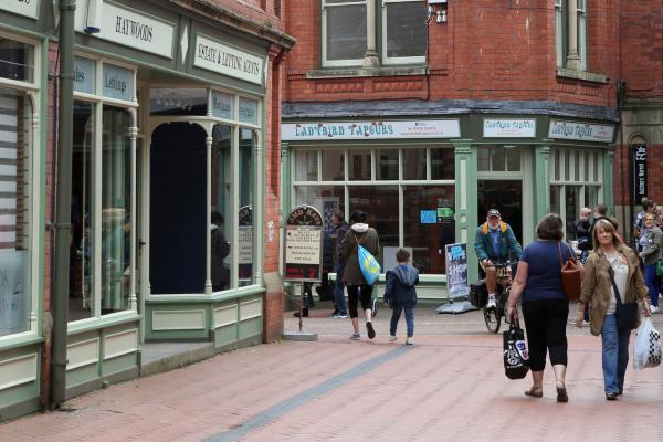 members of the public walking through a town