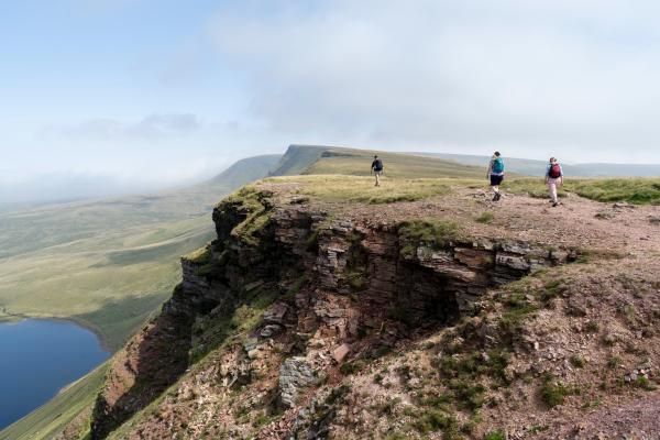 3 walkers on a coastal mountain in Wales