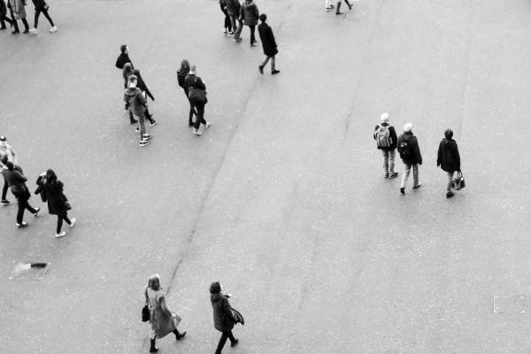 black and white image of people walking down a street