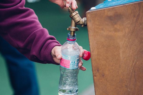 a person filling a water bottle at a water station