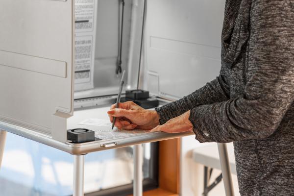 woman filling out voting ballot