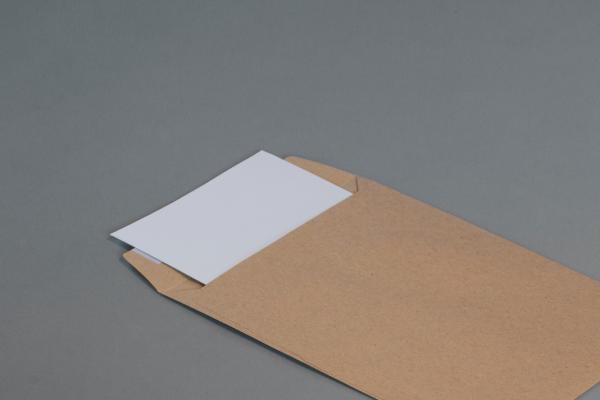 a brown envelope open with a white piece of paper inside